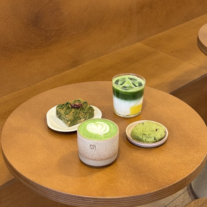 Matcha latte et douceurs sur table en bois